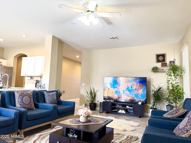 living room featuring a textured ceiling and ceiling fan