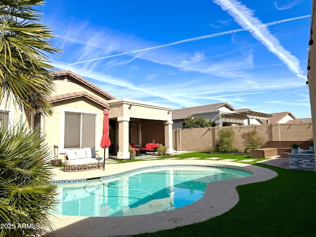 rear view of property featuring a fenced in pool and a patio