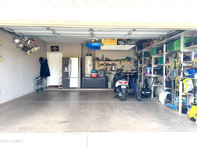 garage featuring stainless steel fridge with ice dispenser, a workshop area, and gas water heater