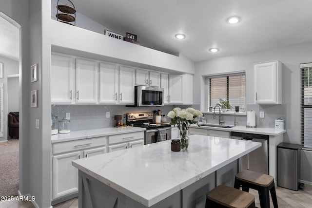 2111 E Rawhide St, Gilbert, AZ 85296 - kitchen featuring appliances with stainless steel finishes, white cabinets, backsplash, a kitchen breakfast bar, and recessed lighting