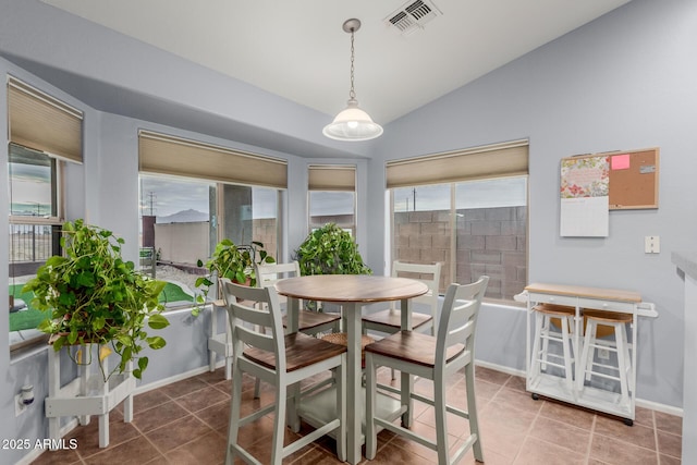 dining space featuring tile patterned flooring and lofted ceiling