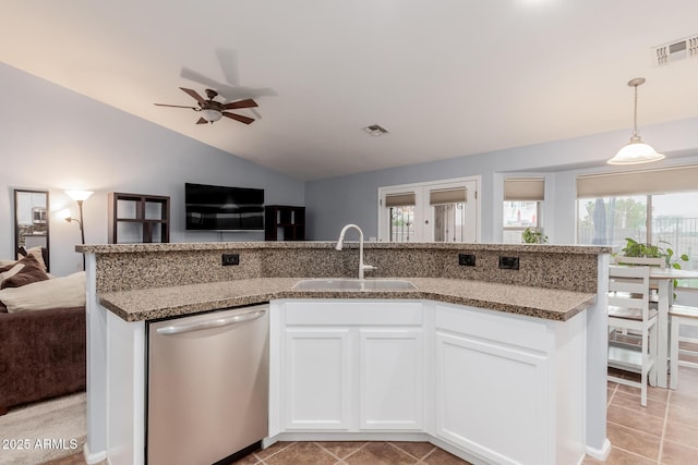 kitchen featuring lofted ceiling, sink, stainless steel dishwasher, ceiling fan, and white cabinetry