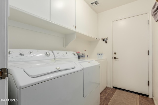 laundry room with washer and dryer and cabinets