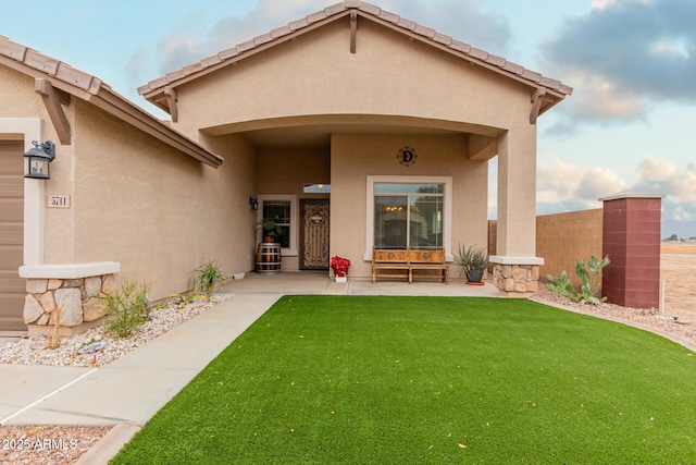 view of exterior entry with a lawn