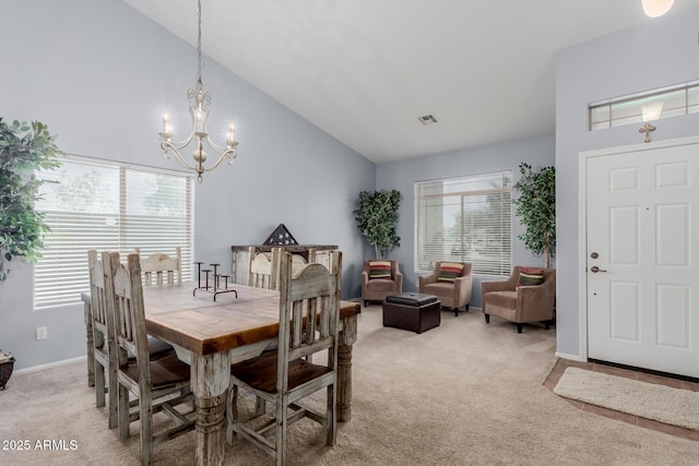 carpeted dining space with high vaulted ceiling and a chandelier