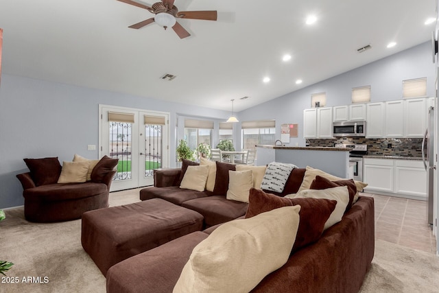 living room with french doors, vaulted ceiling, ceiling fan, and light tile patterned flooring