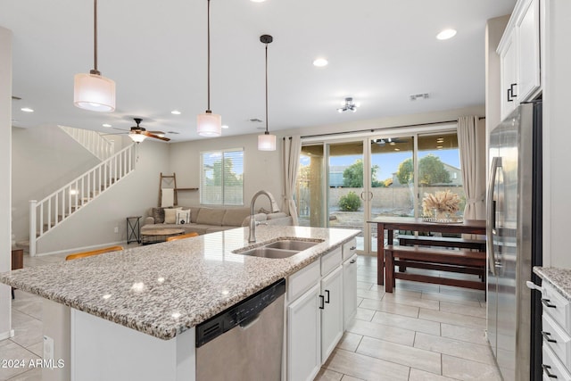 kitchen featuring decorative light fixtures, sink, white cabinetry, an island with sink, and stainless steel appliances