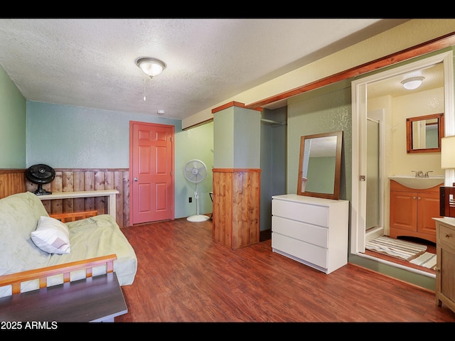 6869 W Ute Trl, Pine, AZ 85544 - bedroom featuring a textured ceiling, wood finished floors, wainscoting, a sink, and a textured wall