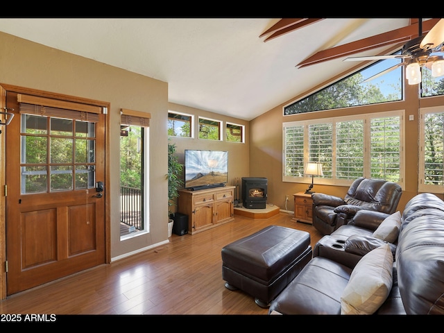 6869 W Ute Trl, Pine, AZ 85544 - living room with a wood stove, ceiling fan, light wood-style flooring, beamed ceiling, and healthy amount of natural light