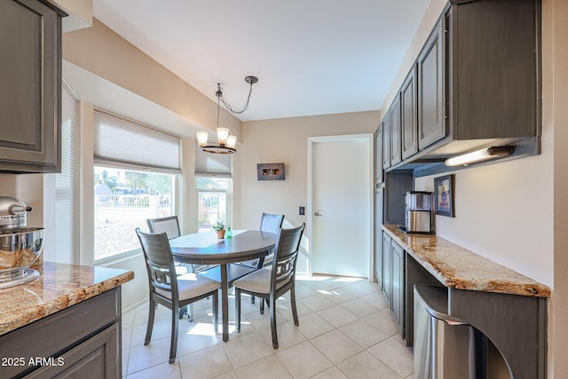 tiled dining space featuring an inviting chandelier