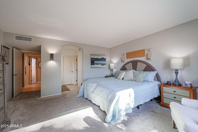 bedroom with light carpet and a textured ceiling