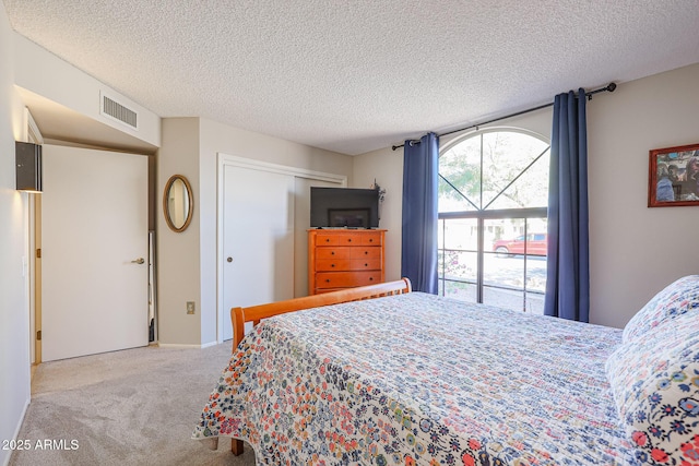 carpeted bedroom with a textured ceiling and a closet