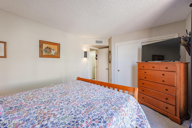 bedroom with carpet flooring, a textured ceiling, and a closet