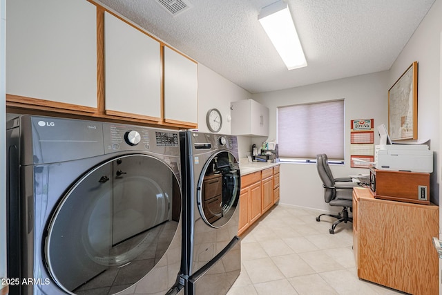 laundry area featuring washer and dryer, light tile patterned flooring, and a textured ceiling