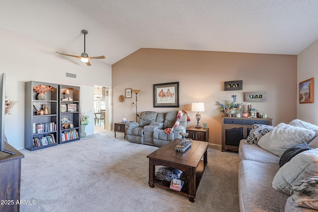 carpeted living room with ceiling fan and lofted ceiling