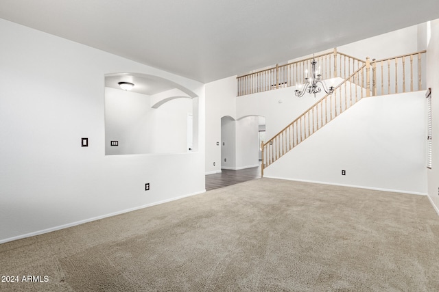 unfurnished living room with carpet and a notable chandelier