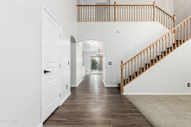 foyer entrance featuring a towering ceiling and dark hardwood / wood-style floors