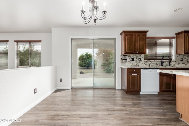 kitchen featuring wood-type flooring, backsplash, white dishwasher, and a notable chandelier