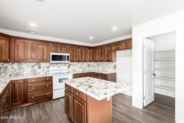 kitchen featuring a center island, white appliances, dark wood-type flooring, decorative backsplash, and light stone countertops