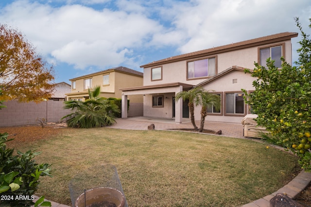 back of house featuring a lawn and a patio area