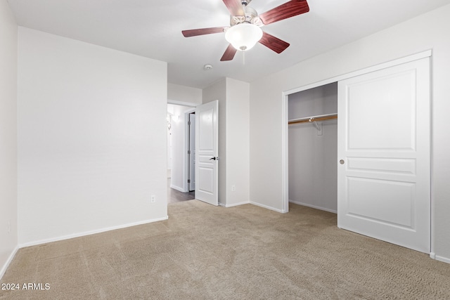 unfurnished bedroom with light carpet, a closet, and ceiling fan