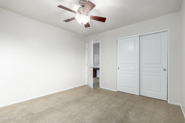 unfurnished bedroom featuring light carpet, a closet, and ceiling fan