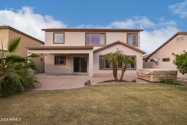 rear view of house featuring a yard and a patio area