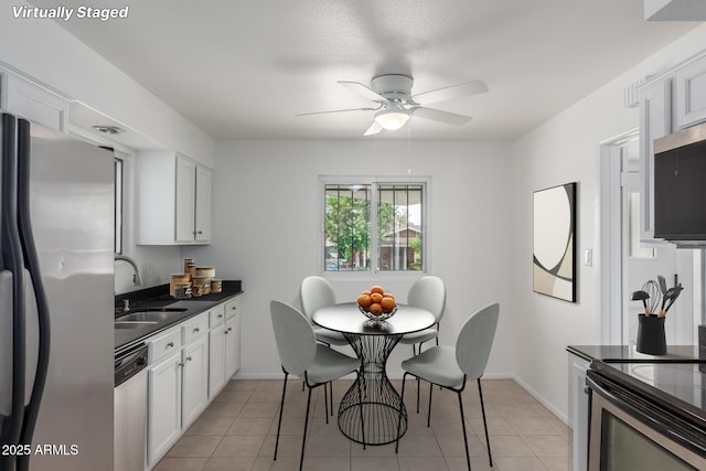 1515 N Saguaro Dr, Tempe, AZ 85288 - kitchen featuring stainless steel appliances, a sink, dark countertops, and white cabinetry