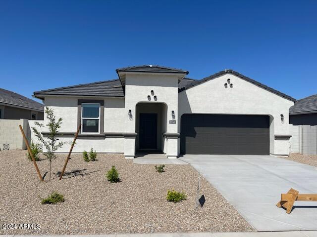 1162 S Mullberry St, Florence, AZ 85132 - mediterranean / spanish-style home with a garage, stucco siding, concrete driveway, and a tile roof