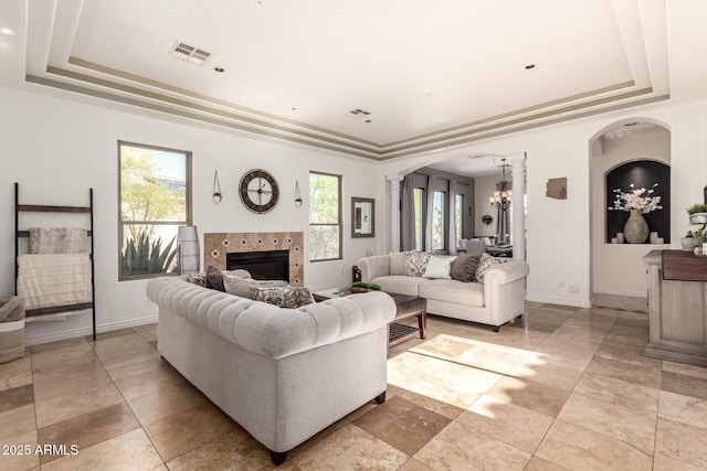 9753 E Suncrest Rd, Scottsdale, AZ 85262 - living area with a raised ceiling, a chandelier, arched walkways, and a tiled fireplace