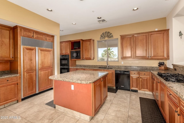9753 E Suncrest Rd, Scottsdale, AZ 85262 - kitchen with black appliances, a sink, brown cabinets, a center island, and light stone counters