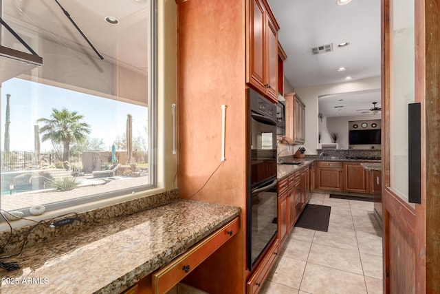 9753 E Suncrest Rd, Scottsdale, AZ 85262 - kitchen featuring light tile patterned flooring, dark stone counters, ceiling fan, brown cabinetry, and recessed lighting