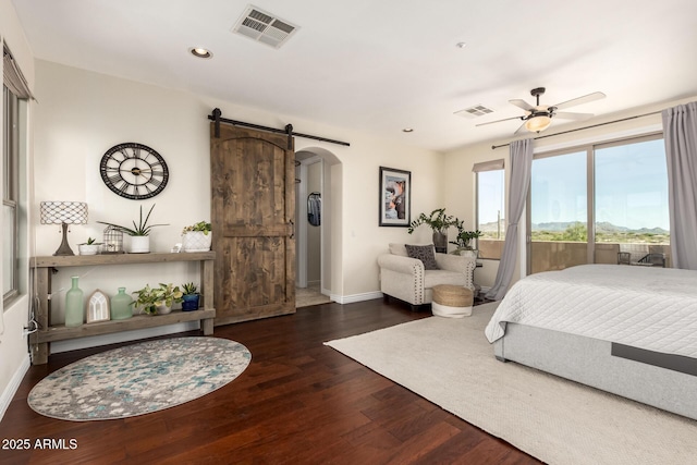 9753 E Suncrest Rd, Scottsdale, AZ 85262 - bedroom featuring arched walkways, a barn door, baseboards, wood finished floors, and recessed lighting