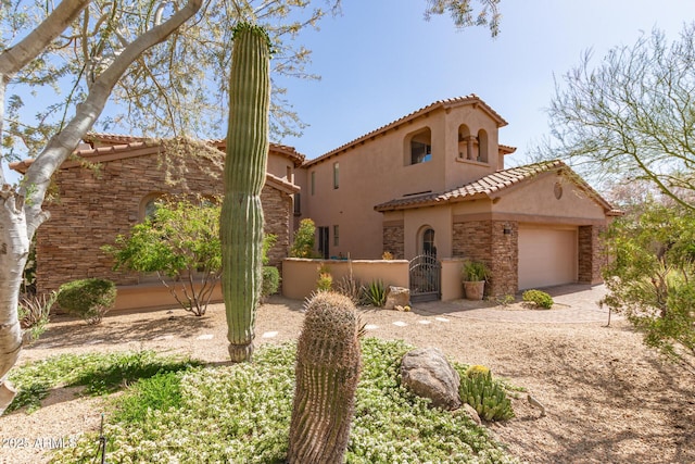 9753 E Suncrest Rd, Scottsdale, AZ 85262 - mediterranean / spanish house featuring a tiled roof, stucco siding, stone siding, and a garage