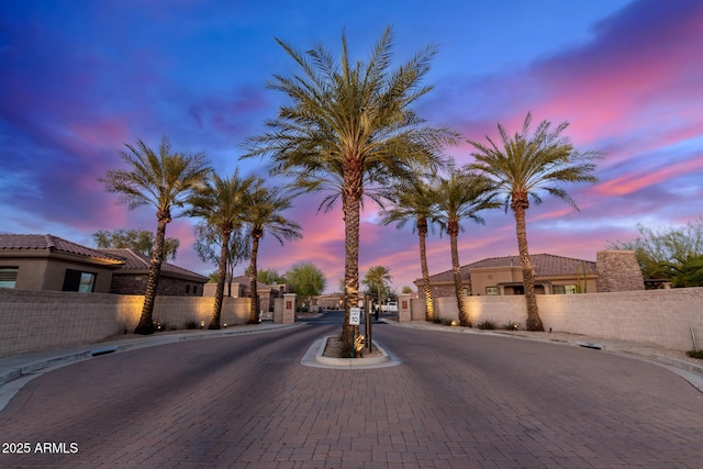 view of street featuring curbs, a gated entry, sidewalks, and a gate