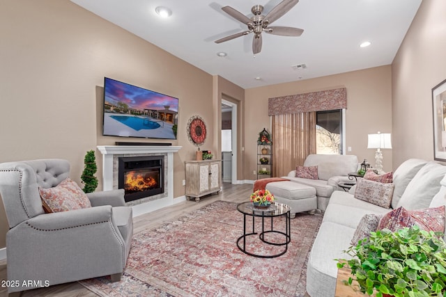 living room featuring visible vents, ceiling fan, recessed lighting, wood finished floors, and a glass covered fireplace