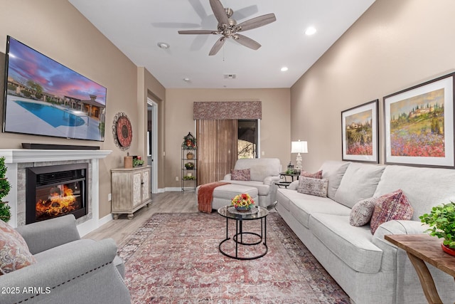 living room with visible vents, baseboards, recessed lighting, a tile fireplace, and wood finished floors