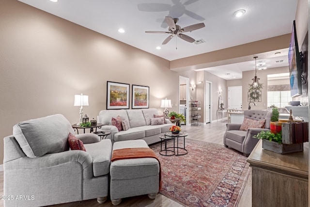 living area featuring wood finished floors, baseboards, visible vents, recessed lighting, and ceiling fan