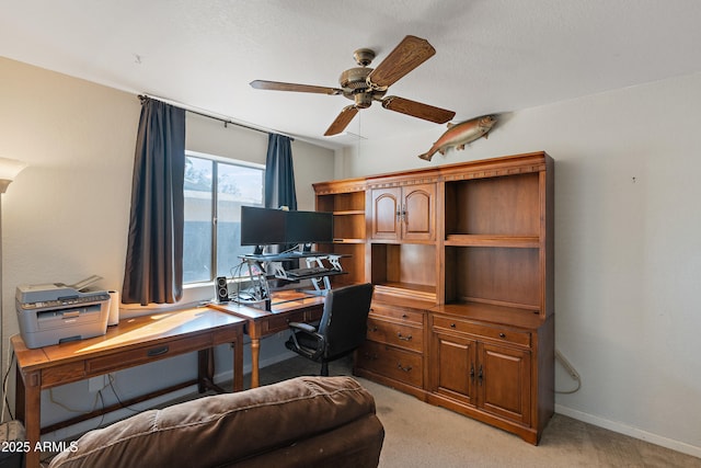 carpeted office space featuring ceiling fan