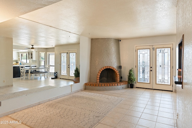 unfurnished living room featuring a brick fireplace, french doors, and light tile patterned flooring