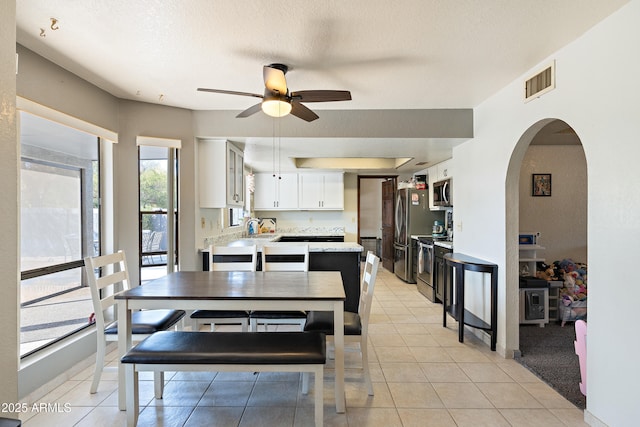 kitchen featuring white cabinetry, appliances with stainless steel finishes, a textured ceiling, and light tile patterned floors