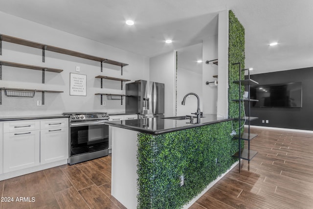 kitchen featuring stainless steel appliances, white cabinetry, sink, and a kitchen island with sink