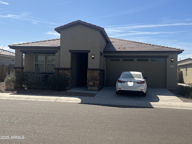 view of front facade with driveway, stone siding, a tiled roof, an attached garage, and stucco siding