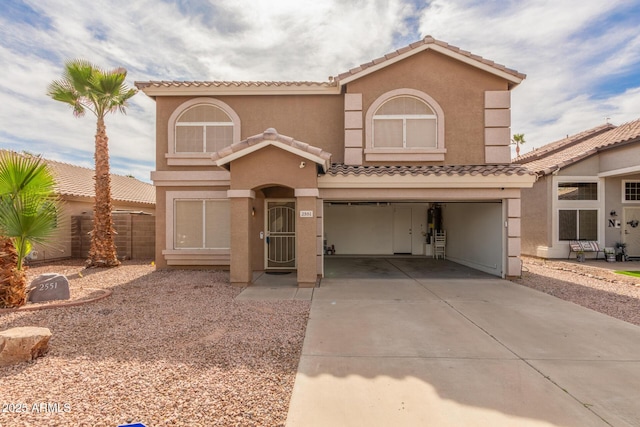 mediterranean / spanish home with a garage, driveway, a tile roof, and stucco siding