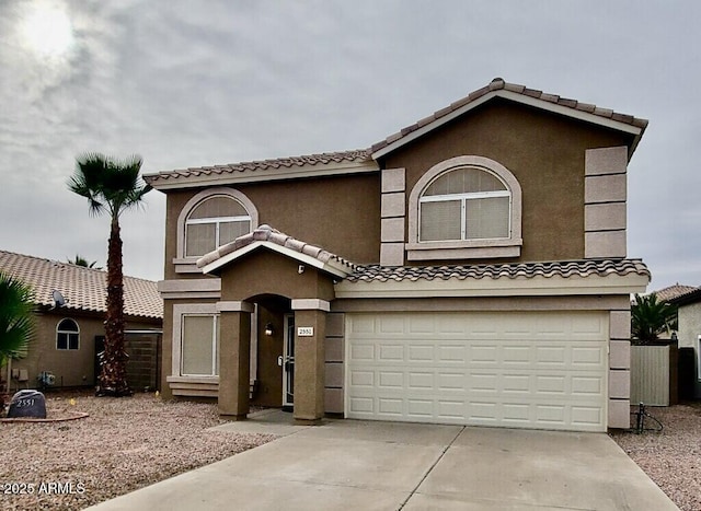 view of front of house with a garage, driveway, a tile roof, and stucco siding