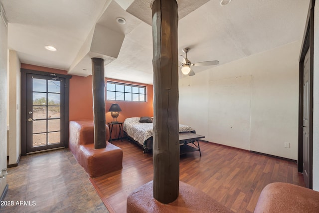 bedroom with baseboards, wood finished floors, a ceiling fan, and multiple windows