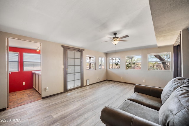 living room with a healthy amount of sunlight, a ceiling fan, and light wood-style floors