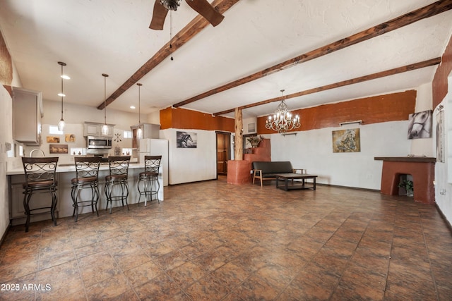 living area featuring beam ceiling, ceiling fan with notable chandelier, and stone finish floor