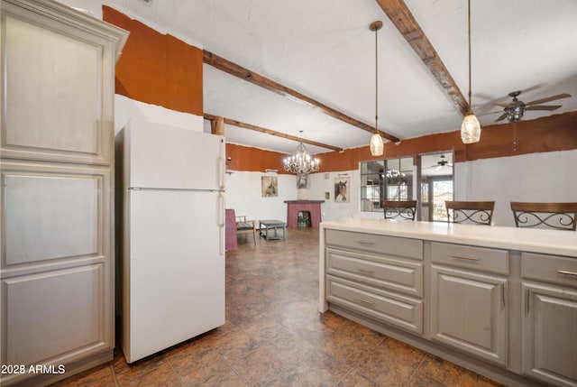 kitchen with pendant lighting, light countertops, freestanding refrigerator, ceiling fan with notable chandelier, and gray cabinets