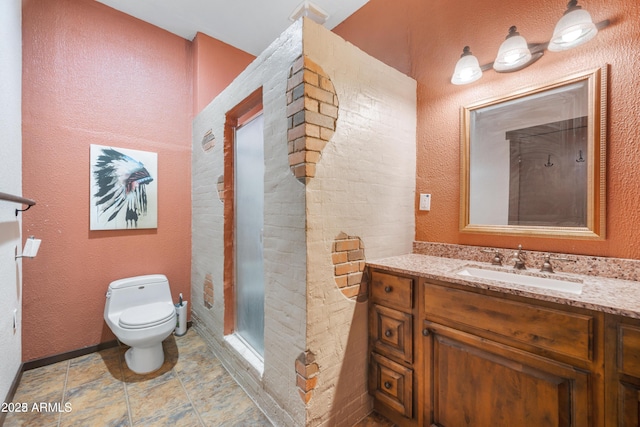 full bath featuring toilet, a textured wall, a shower stall, and vanity
